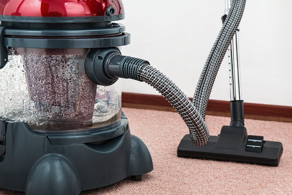 Black and Red Canister Vacuum Cleaner on Floor